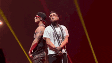 a couple of men are dancing on a stage in front of a crowd .