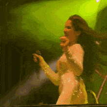 a woman is singing into a microphone on stage