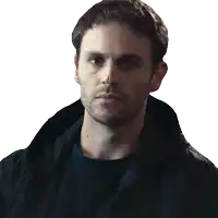 a man with a beard wearing a black jacket looks at the camera