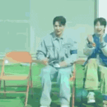 a man in a mermaid costume is sitting on a chair next to another man in a mermaid costume .