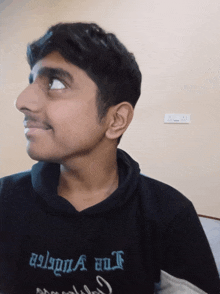 a young man wearing a black sweatshirt that says " the gulf "