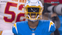 a football player wearing a helmet and goggles is standing on the field .