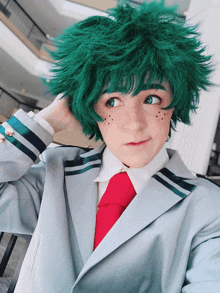 a person with green hair and freckles is wearing a suit
