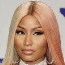 a close up of a woman 's face with blonde and peach hair