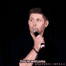 a man holding a microphone says you 're welcome