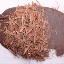 a pile of chocolate shavings on top of a piece of chocolate