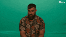 a man with a beard wears a hawaiian shirt with omaha written on the bottom
