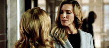 a couple of women are standing next to each other and looking at each other .
