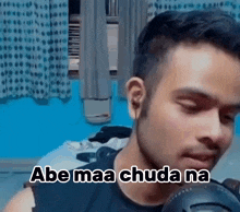 a man wearing headphones is talking into a microphone with the words abe maa chuda na written on the bottom .