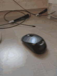 a black computer mouse is laying on a table
