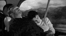 a man and woman are sleeping on a bus .