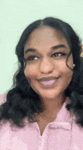 a close up of a woman 's face with a pink jacket