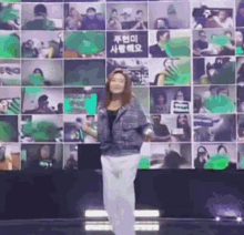 a woman is dancing in front of a wall with a lot of pictures on it .