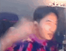 a blurry picture of a person 's face with a purple shirt on