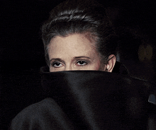 a woman covering her face with a large black collar