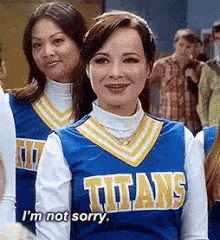 two cheerleaders wearing titans uniforms are standing next to each other and one of them is saying i 'm not sorry