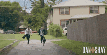 two men in suits and ties are running down a street .