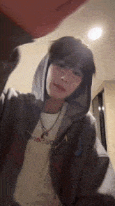 a person wearing a hoodie and a white shirt that says ' abercrombie & fitch ' on it