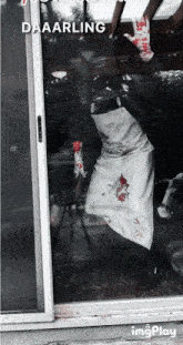 a sliding glass door with a person in a bloody apron on it