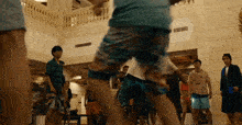 a group of people in shorts are standing in a room