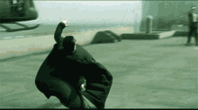 Gif of the slow-motion scene from The Matrix when Neo leans backwards and the bullets pass by him