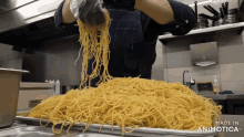 a person is pouring noodles into a tray that says made in animotica