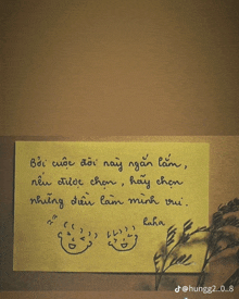 a yellow sticky note with a handwritten message in a foreign language on it