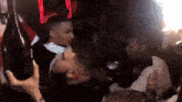 a man holds a bottle of champagne in a crowded room