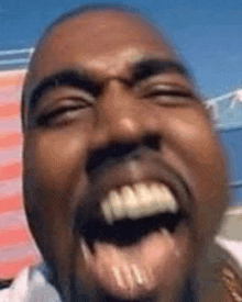 a close up of a man 's face with his mouth open and teeth visible .