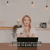 a woman is sitting at a table with a laptop computer and talking to someone .