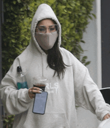 a woman wearing a mask and a hoodie that says rls on it