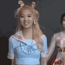 a girl in a sailor suit is smiling and holding a girl 's hand .