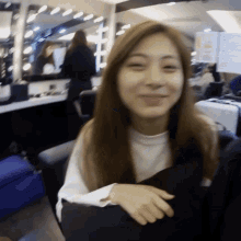a woman with long hair is smiling in a room