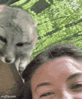 a woman is taking a selfie with her cat .