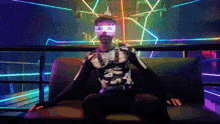 a man is sitting on a couch wearing glow in the dark goggles