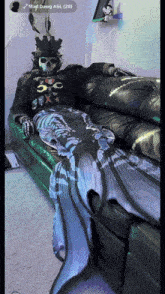 a person in a skeleton costume is sitting on a couch with the name mad dawg asl ( 28 )