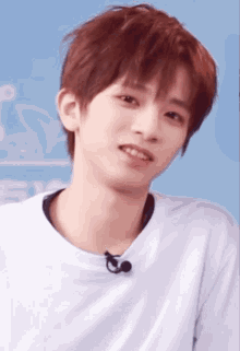 a young man with red hair is wearing a white shirt with a microphone attached to it