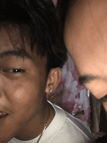 a close up of a man 's ear with a floral background in the background