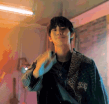 a man in a plaid jacket is standing in a room and making a funny face .