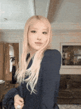 a woman with long blonde hair is standing in a room