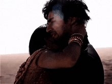 a man and a woman hugging each other with a white background behind them