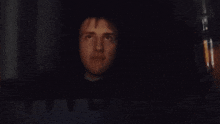 a man 's face is visible in the dark