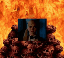 a picture of a girl in a tuxedo is surrounded by skulls and fire