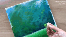 a person is holding a piece of paper with a painting on it that is made in animatica