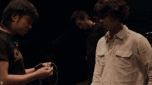 a man in a white shirt is standing in a dark room