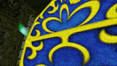 a close up of a blue and yellow item with a swirl design