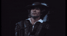 a man with a beard wearing a hat and a leather jacket