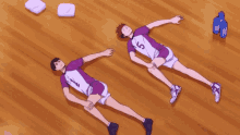 two volleyball players laying on the floor one with the number 15 on his jersey