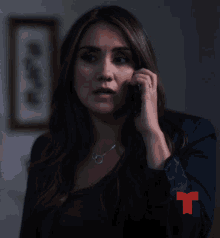 a woman talks on a cell phone with a red t on her sleeve