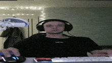 a man wearing headphones sits in front of a keyboard and mouse